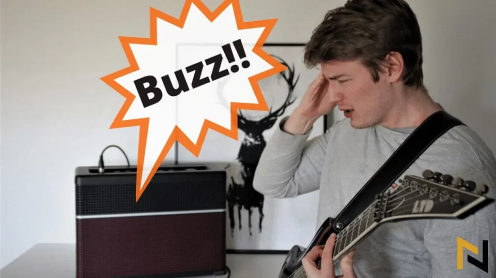 image showing man annoyed by his buzzing amp whilst playing his electric guitar