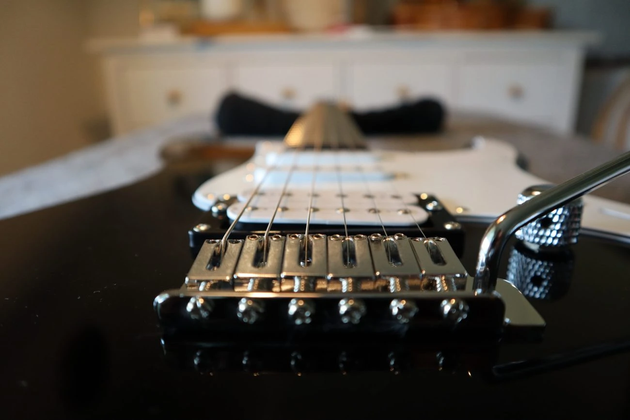 photo displays guitars bridge where the string spacing is usually measured