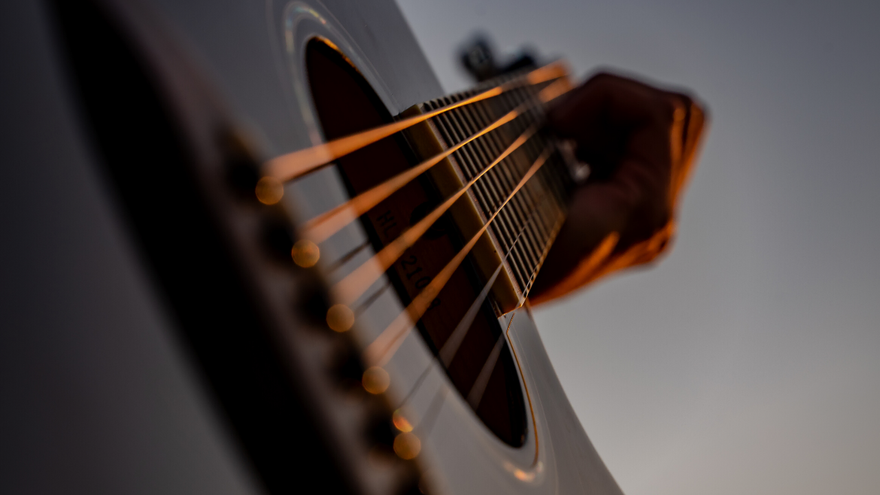 photo displays guitar player playing bluegrass music