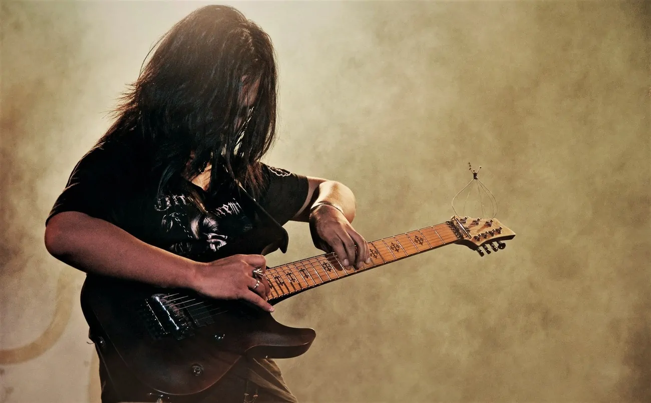 displays guitarist playing a guitar with EMG Pickups