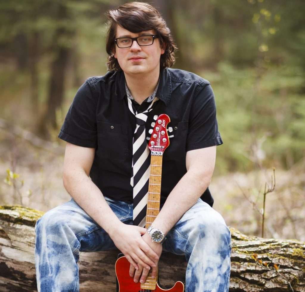 displays David Andrew Wiebe and his guitar