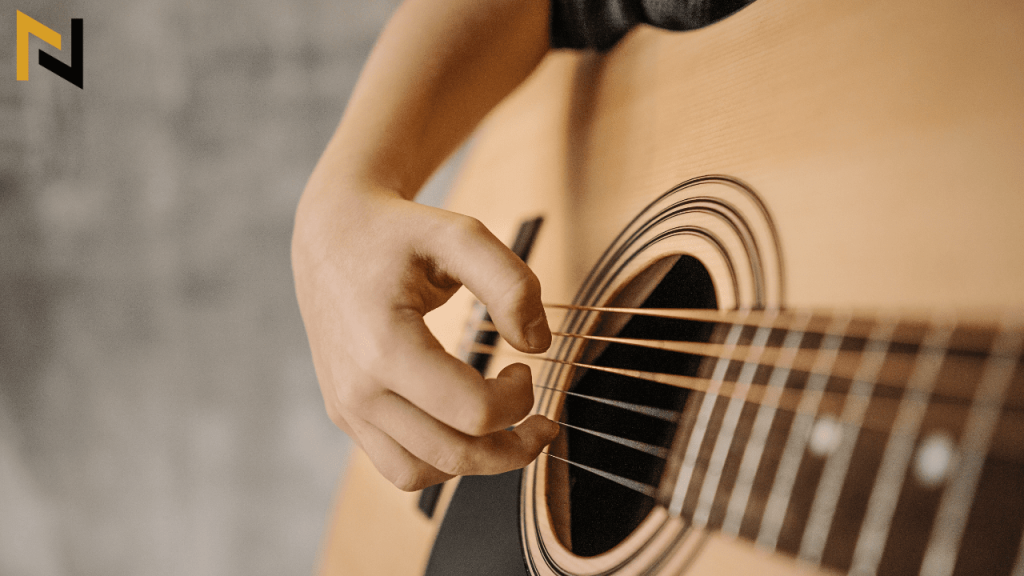 Displays a beginner fingerpicking on guitar