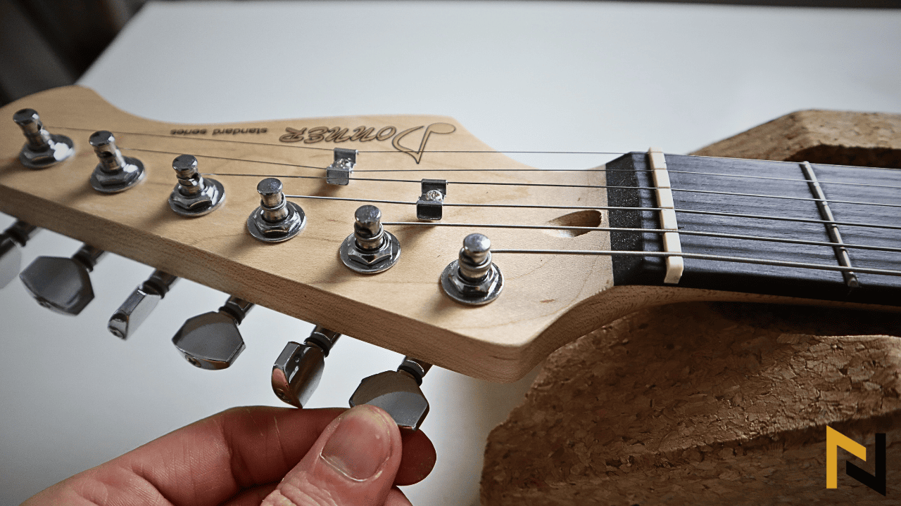 displays a guitar player tuning a guitar