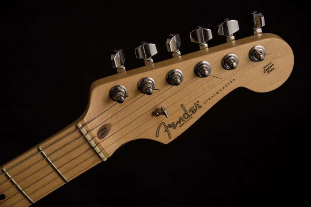 image showing old guitar strings on a fender telecaster headstock