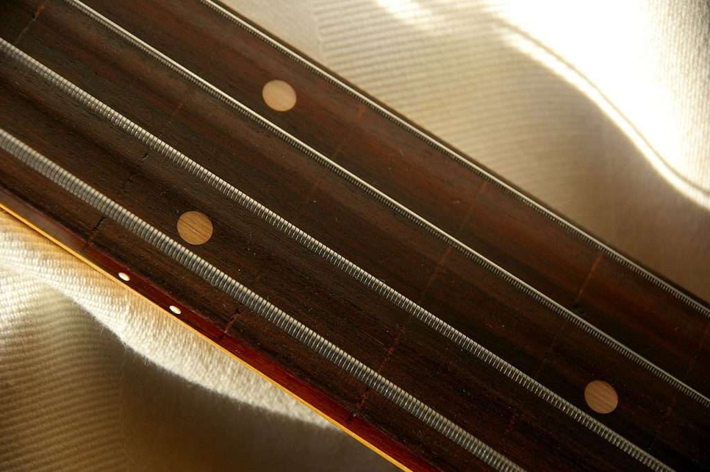 image showing flatwound strings on a 4 string fretless bass neck