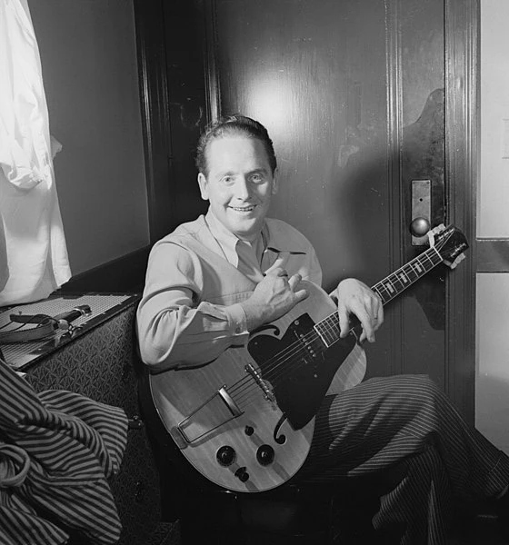 Les Paul seated with his "Log" Guitar